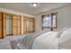 Cozy bedroom boasts natural light, neutral carpet, wood trim windows, and built-in wood closets at 1834 Hennington Ct, Longmont, CO 80501
