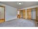 Spacious bedroom with neutral carpet, wood trim, built-in wood closets, and an ensuite half bathroom at 1834 Hennington Ct, Longmont, CO 80501