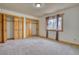 Bright bedroom boasts natural light, neutral carpet, wood trim windows, and built-in wood closets at 1834 Hennington Ct, Longmont, CO 80501