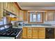 Well-lit kitchen with wood cabinets, tiled countertops, a window over the sink, and stainless steel appliances at 1834 Hennington Ct, Longmont, CO 80501