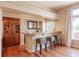 Features an elegant bar area with wooden cabinets, countertop seating, and a window view at 10085 Charissglen Ct, Highlands Ranch, CO 80126