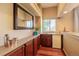 Cozy bar area features wood cabinets, a mirror, mini-fridge and a window view at 10085 Charissglen Ct, Highlands Ranch, CO 80126