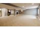 Spacious finished basement with beige carpet, gray walls, and in-home theater setup with projection screen at 10085 Charissglen Ct, Highlands Ranch, CO 80126