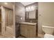 Updated bathroom with modern gray tiling, granite countertops, framed mirror and shower with glass door at 10085 Charissglen Ct, Highlands Ranch, CO 80126