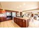 Gourmet kitchen with custom cabinetry, stainless steel appliances, island cooktop, and breakfast table at 10085 Charissglen Ct, Highlands Ranch, CO 80126