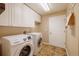 Functional laundry room equipped with modern Samsung washer and dryer and ample storage cabinets at 10085 Charissglen Ct, Highlands Ranch, CO 80126