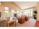 Bright living room with large windows, fireplace, vaulted ceilings and cozy furnishings at 10085 Charissglen Ct, Highlands Ranch, CO 80126