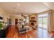 Bright living room with hardwood floors, a cozy fireplace, and large windows at 10085 Charissglen Ct, Highlands Ranch, CO 80126