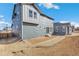 A spacious backyard featuring light brown ground cover and a modern gray home exterior at 13382 E 110Th Way, Commerce City, CO 80022