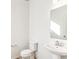 A half-bathroom with white walls, wood-look floors, a toilet, and pedestal sink with mirror at 13382 E 110Th Way, Commerce City, CO 80022