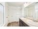 Bright bathroom with double vanity, stone countertop, wood-look tile flooring and white shower at 13382 E 110Th Way, Commerce City, CO 80022