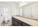 Bright bathroom vanity with stone countertop, a large mirror and wood-look tile flooring at 13382 E 110Th Way, Commerce City, CO 80022