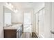 Bright bathroom featuring a double vanity with stone countertop and a glass enclosed shower at 13382 E 110Th Way, Commerce City, CO 80022