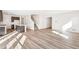 Open-concept living space showcasing wood floors, staircase, and seamless flow into the modern kitchen at 13382 E 110Th Way, Commerce City, CO 80022