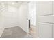 Walk-in closet with wire shelving and neutral carpet, leading to a bright bathroom at 13382 E 110Th Way, Commerce City, CO 80022