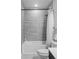 Clean bathroom with a shower/tub combo and gray tile at 6003 Chester Way, Denver, CO 80238