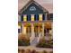 Inviting two-story home with a covered front porch and landscaping at 6003 Chester Way, Denver, CO 80238