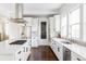 White kitchen with stainless steel appliances and an island at 6003 Chester Way, Denver, CO 80238