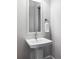 Modern powder room with pedestal sink, mirror, and white finishes at 6003 Chester Way, Denver, CO 80238