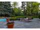 Inviting backyard with a stone fire pit, pool, and lush landscaping for outdoor enjoyment at 1512 Cottonwood Ln, Greenwood Village, CO 80121