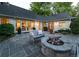 Cozy backyard patio with a stone fire pit, comfortable seating, and lush landscaping at 1512 Cottonwood Ln, Greenwood Village, CO 80121