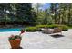 Backyard patio with a fire pit, bench seating, and potted plants surrounded by trees at 1512 Cottonwood Ln, Greenwood Village, CO 80121