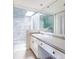 Bright bathroom features a skylight, white vanity, and a marble tiled shower with glass door at 1512 Cottonwood Ln, Greenwood Village, CO 80121