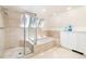 Bright bathroom featuring a tiled shower, soaking tub, and modern finishes at 1512 Cottonwood Ln, Greenwood Village, CO 80121