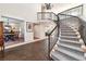 Elegant foyer with a curved staircase, brick flooring, and views of the dining room at 1512 Cottonwood Ln, Greenwood Village, CO 80121