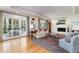 Bright living room featuring a fireplace, hardwood floors, and access to an outdoor patio through French doors at 1512 Cottonwood Ln, Greenwood Village, CO 80121