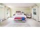 Bright bedroom showcasing a bed with built-in headboard shelving, natural light, and neutral carpet at 1512 Cottonwood Ln, Greenwood Village, CO 80121