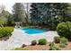 Backyard pool with surrounding patio, mature trees, and a pool house with chairs at 1512 Cottonwood Ln, Greenwood Village, CO 80121