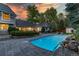 Stunning backyard featuring a pool, manicured greenery and a charming home exterior under a vibrant sunset sky at 1512 Cottonwood Ln, Greenwood Village, CO 80121