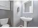 Half bathroom with white sink, toilet and medicine cabinet at 12133 Hannibal St, Commerce City, CO 80603