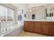 The bright bathroom offers double sinks, wood cabinetry, a soaking tub, and a decorative plant ledge at 12133 Hannibal St, Commerce City, CO 80603
