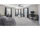 Spacious room featuring a ceiling fan, three windows, carpeted floors and multiple computer work stations at 12133 Hannibal St, Commerce City, CO 80603
