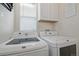 Laundry room with white washer and dryer, and storage cabinets at 12133 Hannibal St, Commerce City, CO 80603