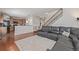 Open-concept living room with staircase, kitchen, and leather sectional sofa at 12133 Hannibal St, Commerce City, CO 80603