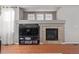 Cozy living room featuring a fireplace, TV, and hardwood floors at 12133 Hannibal St, Commerce City, CO 80603