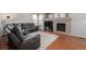 Comfortable living room featuring a fireplace, hardwood floors, a sectional sofa, and neutral decor at 12133 Hannibal St, Commerce City, CO 80603