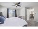 A main bedroom with neutral color scheme and ceiling fan leading to the staircase and main living area at 12133 Hannibal St, Commerce City, CO 80603
