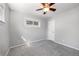Bedroom features soft grey walls, neutral carpet, ceiling fan, and natural light from window at 1560 Pueblo Ct, Thornton, CO 80229