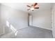 Bright, carpeted bedroom with open doorway and ceiling fan at 1560 Pueblo Ct, Thornton, CO 80229