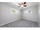 Bedroom featuring two windows, soft grey walls, neutral carpet, and ceiling fan at 1560 Pueblo Ct, Thornton, CO 80229