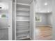Open closet features ample shelving and opens to a bedroom and living room area at 1560 Pueblo Ct, Thornton, CO 80229