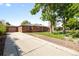 Brick exterior home with a private driveway, beautiful trees, and lush landscaping at 1560 Pueblo Ct, Thornton, CO 80229