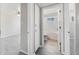 Hallway view of bathroom and bedroom featuring wood-style floors and white wall accents at 1560 Pueblo Ct, Thornton, CO 80229
