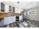 Bright kitchen with white cabinets, mosaic backsplash, stainless steel fridge, and unique tile floor at 1560 Pueblo Ct, Thornton, CO 80229