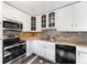 Well-lit kitchen featuring stainless steel appliances, ample cabinet space, and stylish backsplash at 1560 Pueblo Ct, Thornton, CO 80229
