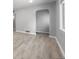 Clean, freshly painted living room with light-colored wood floors and a view into the hallway at 1560 Pueblo Ct, Thornton, CO 80229